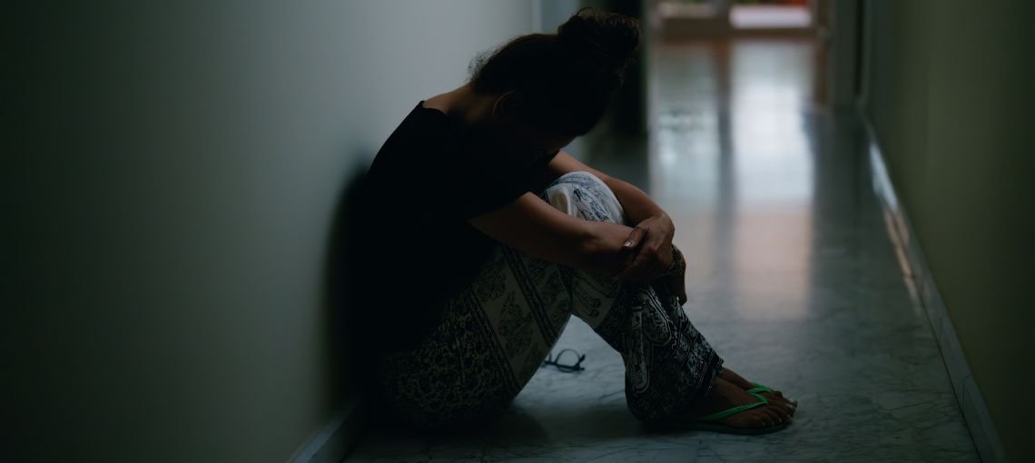 Stressed professional at desk experiencing anxiety and burnout from unresolved trauma