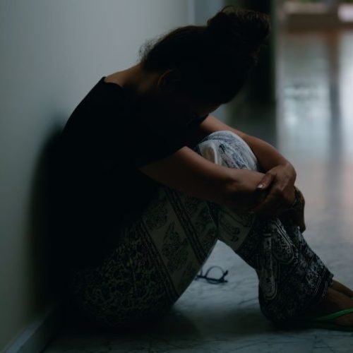 Stressed professional at desk experiencing anxiety and burnout from unresolved trauma